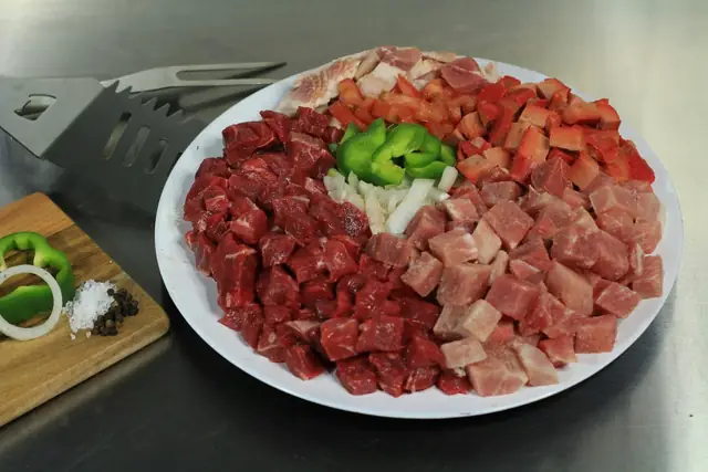 Selección de carne cortada en cubos con chile y cebolla al centro.